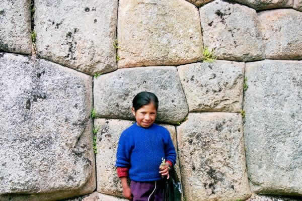 Petite bergère posant devant un mur inca